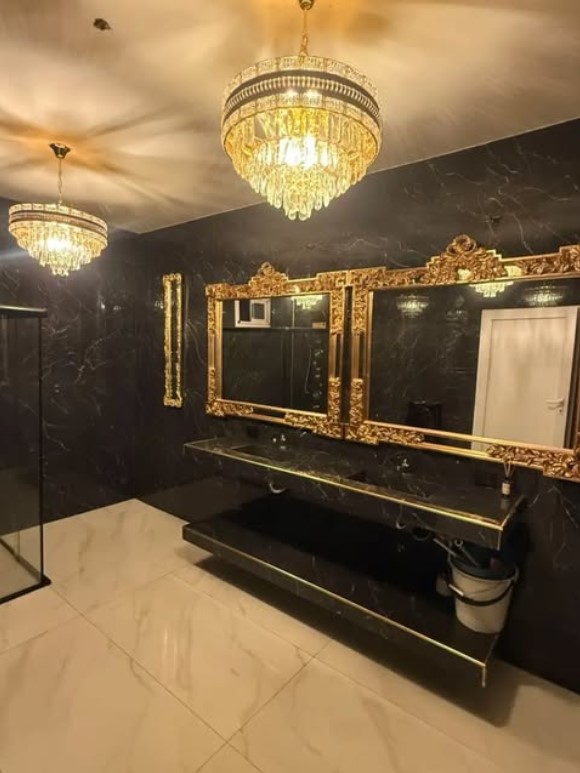 Toilette de gala con arañas de cristal y espejos dorados