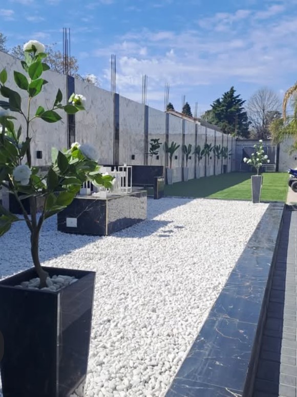 Jardín exterior con paseo de mármol y flores blancas